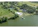 Waterfront property featuring a modern home with a pool, private dock, and stunning lake views from above at 11313 Knights Griffin Rd, Thonotosassa, FL 33592