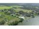 Expansive aerial view showcases the lakefront property with a tennis court, dock, and lush surroundings at 11313 Knights Griffin Rd, Thonotosassa, FL 33592
