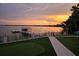 Backyard putting green and covered boat lift on the lake during a colorful sunset at 11313 Knights Griffin Rd, Thonotosassa, FL 33592
