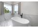Luxurious bathroom with a modern freestanding tub and stunning views of the surrounding nature at 11313 Knights Griffin Rd, Thonotosassa, FL 33592