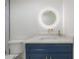 Bathroom with accent cabinet, modern fixtures, circular mirror and tile backsplash at 11313 Knights Griffin Rd, Thonotosassa, FL 33592