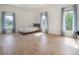 Bright bedroom with wood floors, three windows and light-blocking gray curtains at 11313 Knights Griffin Rd, Thonotosassa, FL 33592