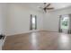 Bright bedroom with wood floors, two windows and light-blocking gray curtains at 11313 Knights Griffin Rd, Thonotosassa, FL 33592