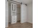 Walk-in closet showcasing custom built-ins and sliding barn door at 11313 Knights Griffin Rd, Thonotosassa, FL 33592