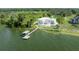 Beautiful waterfront home showcasing a modern design, private dock, and lush landscaping from an elevated perspective at 11313 Knights Griffin Rd, Thonotosassa, FL 33592