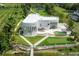 Beautiful waterfront home showcasing a modern design, private dock, putting green, and pool from an elevated perspective at 11313 Knights Griffin Rd, Thonotosassa, FL 33592