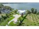 Aerial view of a modern white home with a circular driveway on a beautifully landscaped lot at 11313 Knights Griffin Rd, Thonotosassa, FL 33592