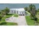 Stunning waterfront property featuring a modern, white home with lush landscaping and a private dock overlooking the serene lake at 11313 Knights Griffin Rd, Thonotosassa, FL 33592