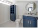 Bathroom with accent cabinet, modern fixtures, circular mirror and tile backsplash at 11313 Knights Griffin Rd, Thonotosassa, FL 33592