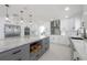 Open concept kitchen features a large island with pendant lighting, white cabinets, and stainless appliances at 11313 Knights Griffin Rd, Thonotosassa, FL 33592
