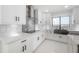Modern kitchen boasts white cabinets, black hardware, marble backsplash, and a view of the water at 11313 Knights Griffin Rd, Thonotosassa, FL 33592