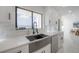Modern kitchen with white cabinets, marble countertops, a black faucet, and a view of the water at 11313 Knights Griffin Rd, Thonotosassa, FL 33592
