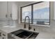 Kitchen sink features black hardware, white cabinetry and countertops, with water view through the window at 11313 Knights Griffin Rd, Thonotosassa, FL 33592