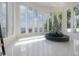 Sunlit living room boasts floor-to-ceiling windows with picturesque lake views at 11313 Knights Griffin Rd, Thonotosassa, FL 33592