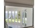 Bright living room boasts waterfront views through floor-to-ceiling windows and a charming aesthetic at 11313 Knights Griffin Rd, Thonotosassa, FL 33592