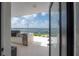 Outdoor kitchen with a built-in grill, stainless steel refrigerator, and scenic waterfront view at 11313 Knights Griffin Rd, Thonotosassa, FL 33592
