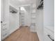 Walk-in closet with custom shelving, wood floors, and multiple hanging rods provides ample storage at 11313 Knights Griffin Rd, Thonotosassa, FL 33592