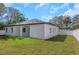 Exterior view of home featuring a covered patio and spacious backyard with a privacy fence at 1213 E Lemon St, Tarpon Springs, FL 34689