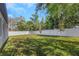 Large, grassy backyard enclosed with a white privacy fence and mature trees at 1213 E Lemon St, Tarpon Springs, FL 34689