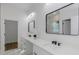 Bathroom features double sinks, black hardware, white cabinets, and modern mirrors at 1213 E Lemon St, Tarpon Springs, FL 34689