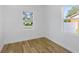 Bedroom with two windows, light hardwood floors, and neutral paint at 1213 E Lemon St, Tarpon Springs, FL 34689