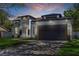Exterior elevation of a modern house with a driveway, garage and manicured lawn at 1213 E Lemon St, Tarpon Springs, FL 34689
