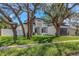 Striking modern home with lush landscaping, a well-manicured lawn, and mature trees in a desirable neighborhood setting at 1213 E Lemon St, Tarpon Springs, FL 34689