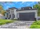 Contemporary home showcases an attractive facade with a prominent garage and an expansive paved driveway at 1213 E Lemon St, Tarpon Springs, FL 34689