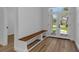 Bright foyer featuring wood-look floors, a built-in bench, and large windows at 1213 E Lemon St, Tarpon Springs, FL 34689