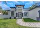 Elegant home featuring a modern exterior design, complemented by a paved walkway and meticulously maintained lawn at 1213 E Lemon St, Tarpon Springs, FL 34689