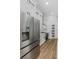 Sleek kitchen featuring stainless steel refrigerator and appliances, white cabinets, and hardwood floors at 1213 E Lemon St, Tarpon Springs, FL 34689