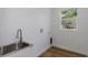 Bright laundry room features wood-look flooring and utility sink beneath a modern faucet at 1213 E Lemon St, Tarpon Springs, FL 34689