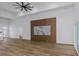 Open living room with wood floors, tray ceiling, modern fan, and accent wall with a marble feature at 1213 E Lemon St, Tarpon Springs, FL 34689