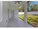 Covered patio overlooks grassy backyard with white privacy fence and mature trees at 1213 E Lemon St, Tarpon Springs, FL 34689