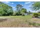 Spacious backyard featuring a storage shed, mature trees, and ample space for outdoor activities at 1237 Oak Valley Dr, Seffner, FL 33584