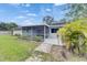 Charming backyard with lush lawn, stone patio, and a screened-in porch, creating a perfect outdoor retreat at 1237 Oak Valley Dr, Seffner, FL 33584