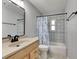 Bathroom features a single sink vanity, framed mirror, tub shower with tiled walls, and floral curtain at 1237 Oak Valley Dr, Seffner, FL 33584