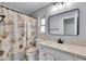 Bathroom featuring a shower with seashell-themed curtain, single sink vanity, and a framed mirror at 1237 Oak Valley Dr, Seffner, FL 33584