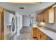 Kitchen features wood cabinets, stainless steel appliances, and tile flooring, leading to the living room at 1237 Oak Valley Dr, Seffner, FL 33584