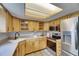Bright kitchen with wood cabinets, light countertops, tile floors, and stainless steel appliances at 1237 Oak Valley Dr, Seffner, FL 33584