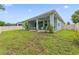Backyard featuring a lush green lawn, a covered patio, and a privacy fence, perfect for outdoor living at 1237 Windy Bay Shl, Tarpon Springs, FL 34689