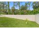 Spacious backyard featuring a well-maintained lawn, privacy fence, and mature trees at 1237 Windy Bay Shl, Tarpon Springs, FL 34689