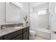 Bathroom featuring a granite countertop, dark wood cabinets, and a tub and shower with tile surround at 1237 Windy Bay Shl, Tarpon Springs, FL 34689