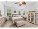 Bright bedroom with a ceiling fan and multiple windows at 1237 Windy Bay Shl, Tarpon Springs, FL 34689