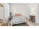 Bright bedroom featuring a bed with floral quilt, wood furniture, and large window for natural light at 1237 Windy Bay Shl, Tarpon Springs, FL 34689