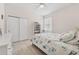 Cozy bedroom with sliding door closet and light tile floors, brightened by a sun-filled window at 1237 Windy Bay Shl, Tarpon Springs, FL 34689