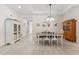 Bright dining room with neutral tile flooring, a tray ceiling, a farmhouse-style table, and decorative furnishings at 1237 Windy Bay Shl, Tarpon Springs, FL 34689