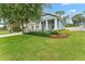 View of the house showing the side lawn, and view of the columns and covered porch from the yard at 1237 Windy Bay Shl, Tarpon Springs, FL 34689