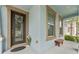 Covered porch with a stained-glass front door, a side bench, accent plants, and exterior trim at 1237 Windy Bay Shl, Tarpon Springs, FL 34689
