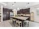 Spacious kitchen featuring a marble island, stainless steel appliances, dark cabinets, and pendant lighting at 1237 Windy Bay Shl, Tarpon Springs, FL 34689